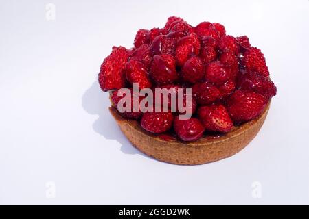 Tartelet aux fraises sauvages sur fond blanc. Tarte aux fraises et sablés pour une personne. Banque D'Images