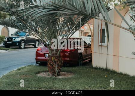 Red Super car en plein air devant une maison à la maison Yard dans la ville avec des palmiers autour Banque D'Images