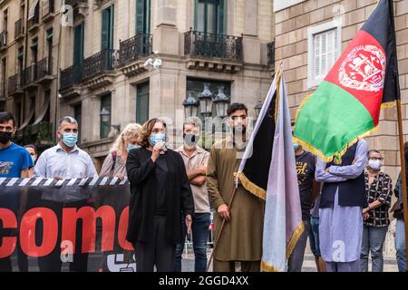 Barcelone, Espagne. 30 août 2021. ADA Colau, maire de Barcelone, est vu parler dans un micro à côté des manifestants avec le drapeau afghan. Une trentaine de personnes appartenant à la communauté afghane de Barcelone ont exigé ce lundi 30 août, devant la Generalitat de Catalogne, le retour en toute sécurité de leurs parents encore piégés dans le pays. Crédit : DAX Images/Alamy Live News Banque D'Images