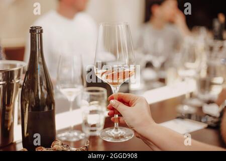 Verres avec différents types de vin et mains humaines tenant des verres à vin en arrière-plan. Dégustation de vin Banque D'Images