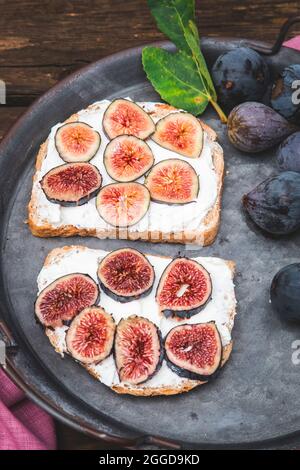 Bruschetta à la ricotta douce aux figues mûres servie sur un plateau. Photo verticale Banque D'Images