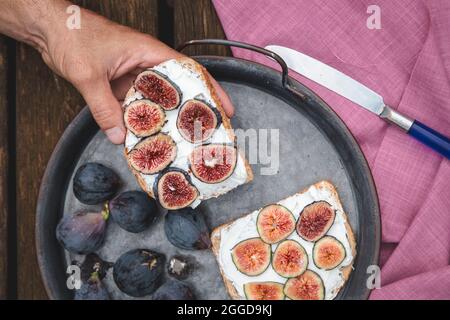 Sandwich à la ricotta à la main avec figues fraîches Banque D'Images