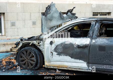 Une épave de voiture brûlée abandonnée dans la rue voiture fortement endommagée Banque D'Images