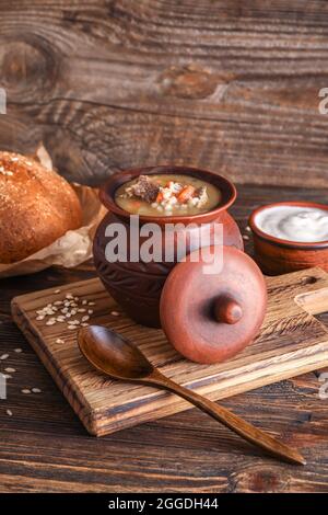 Casserole avec soupe savoureuse à l'orge de bœuf sur table Banque D'Images