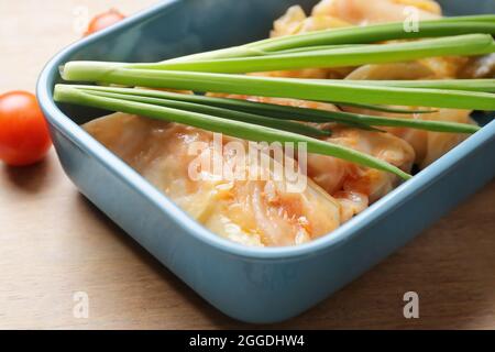 Plat de cuisson avec de savoureux petits pains de chou farcis sur la table, en gros plan Banque D'Images