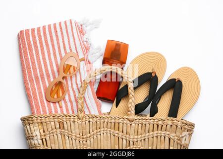 Sac élégant avec accessoires de plage et crème solaire sur fond blanc Banque D'Images