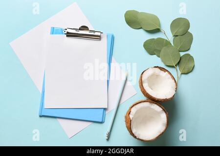 Presse-papiers avec feuille de papier vierge, crayon et noix de coco sur fond de couleur Banque D'Images