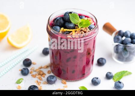 Smoothie bio épais aux baies d'acai dans un pot en verre, fond blanc Banque D'Images
