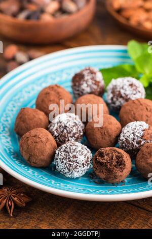 Truffes au chocolat vegan maison avec crème de noix de coco enrobée de flocons de noix de coco et de poudre de cacao Banque D'Images