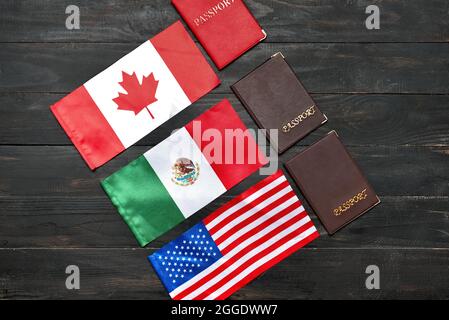 Différents drapeaux et passeports sur fond de bois sombre Banque D'Images