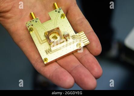 31 août 2021, Basse-Saxe, Brunswick: Le physicien Markus Duwe présente un processeur quantique sur un prototype d'ordinateur quantique au Physikalisch-Technische Bundesanstalt PTB. La Basse-Saxe veut faire avancer la technologie quantique avec des sommes de milliards. Plus de 1.5 milliards d'euros seront consacrés à la nouvelle technologie d'ici 2030, a annoncé l'association de recherche de Basse-Saxe 'Quantum Valley Basse-Saxe'. D'ici 2025, le premier ordinateur quantique de l'État doit être mis en service. Photo: Julian Stratenschulte/dpa Banque D'Images
