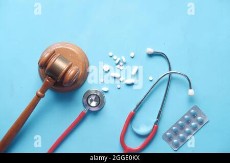 Vue de dessus du gavel, du stéthoscope et des pilules sur fond bleu Banque D'Images