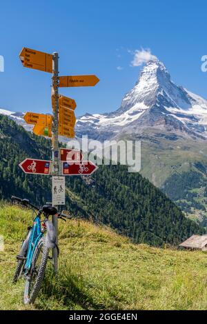 Des sentiers de randonnée pédestre indiquent avec VTT penché et Matterhorn en arrière-plan, Zermatt, Valais, Suisse Banque D'Images