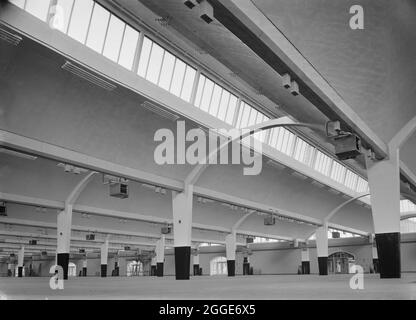 L'intérieur de la boutique de production de l'usine de radio Murphy, montrant le clerestory vitré d'un toit en béton de charpente en porte-à-faux au-dessus d'une des baies. La construction de la nouvelle usine de radio Murphy, d'une superficie de 300,000 000 pieds carrés, a débuté en octobre 1953. Le premier contrat portait sur l'atelier de production, la chaufferie, les annexes, les routes, le drainage et les travaux externes sur le site. L'atelier de production comprenait des toits en béton de coquille en porte-à-faux couvrant la largeur du bâtiment en 3 baies, tandis que la longueur était composée de quinze baies de 180 pieds de long chacune et de 30 pieds de large. Les toits avaient des cléricates de vitrage face à l'eas Banque D'Images