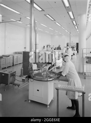 Une équipe de femmes travaillant dans la salle de remplissage des pesticides des laboratoires NaPP. Les laboratoires NaPP ont été construits par Laing Management Contracting pour NaPP Pharmaceutical Group, dont les travaux ont commencé en octobre 1980. Le projet de construction comprenait un bâtiment et un entrepôt de production pharmaceutique, des services de recherche et de laboratoire, des bureaux administratifs, un restaurant et un auditorium. L'édifice, conçu par Arthur Erickson Architects, basé à Toronto, se compose de trois édifices reliés ensemble pour former un seul complexe. Assis à 1200 mm au-dessus de la terre environnante sur un podium en béton, il a aussi Banque D'Images