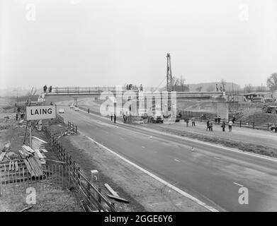 Vue sur une passerelle en construction dans la zone de service de Newport Pagnell sur la M1, sur l'autoroute de Londres à Yorkshire, montrant la circulation sur la chaussée en direction du nord. Cette image a été cataloguée dans le cadre du projet Breaking New Ground en partenariat avec la John Laing Charitable Trust en 2019-20. Banque D'Images