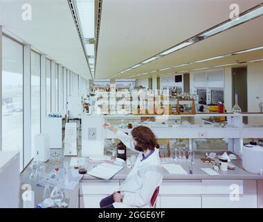 Homme travaillant dans le laboratoire de stabilité et d'analyse des laboratoires NaPP. Les laboratoires NaPP ont été construits par Laing Management Contracting pour NaPP Pharmaceutical Group, dont les travaux ont commencé en octobre 1980. Le projet de construction comprenait un bâtiment et un entrepôt de production pharmaceutique, des services de recherche et de laboratoire, des bureaux administratifs, un restaurant et un auditorium. L'édifice, conçu par Arthur Erickson Architects, basé à Toronto, se compose de trois édifices reliés ensemble pour former un seul complexe. Assise à 1200 mm au-dessus de la terre environnante sur un podium en béton, elle aussi ha Banque D'Images