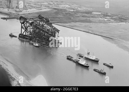 Vue aérienne des remorqueurs remorquant la plate-forme pétrolière Graythorp I le long de l'estuaire de Tees loin de Graythorp. Au début des années 1970, Laing pipelines Offshore a construit le chantier de fabrication Graythorp et le quai sec sur le site de l'ancien chantier naval William Gray. L'entreprise a créé un quai sec qui a été utilisé pour la construction de plates-formes fixes de forage en mer du Nord pour le projet pétrolier BP en mer du Nord. Graythorp J'ai eu sa cérémonie de baptême le 4 juin et a été lancé le samedi 29 juin 1974, se dirigeant vers le champ pétrolifère de Forties à 250 miles de distance. Banque D'Images