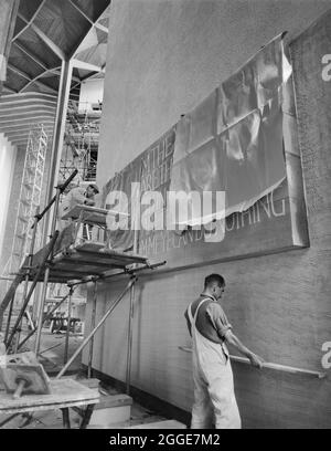 Deux hommes plâtrage un mur à la cathédrale de Coventry autour d'un panneau inscrit par Ralph Beyer. Cette image a été cataloguée dans le cadre du projet Breaking New Ground en partenariat avec la John Laing Charitable Trust en 2019-20. Banque D'Images