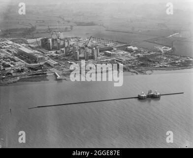 Vue aérienne du nord-ouest sur la rivière Severn montrant la centrale nucléaire de Berkeley et ses réacteurs pendant la construction. La centrale nucléaire de Berkeley a été la première centrale nucléaire commerciale au Royaume-Uni et l'une des premières générations de réacteurs nucléaires en Grande-Bretagne. Il avait deux réacteurs Magnox et était l'une des quatre stations situées près de l'embouchure de la rivière Severn et du chenal Bristol. Laing était les ingénieurs civils pour le projet, les travaux commençant le 7 janvier 1957. La centrale nucléaire est entrée en service en 1962, mais a depuis été désaffectée de fol Banque D'Images