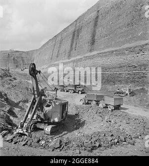 Les dernières tonnes de charbon extraites de la mine opencast de Carrington Coppice, avec une coupe de 178 pieds de profondeur qui menace au-dessus. John Laing and son Ltd a lancé des opérations d'exploitation minière en 1942 pour répondre aux besoins de la guerre. Le travail a été élargi par la compagnie après la guerre. Carrington's Coppice était le plus grand site que l'entreprise travaillait et était le plus profond site d'opencast en Grande-Bretagne. Les travaux ont commencé en 1947 et, en 1949, la veine a été travaillée après que 523,623 tonnes de charbon aient été extraites du site. En août 1950, les terres ont été réintégrées pour une utilisation agricole. Banque D'Images
