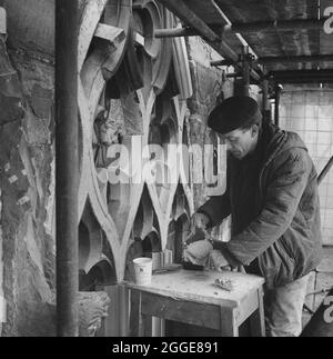 Un tailleur de pierre travaillant à la cathédrale de Carlisle appliquant la Cératine SBD pendant la restauration sur la traserie d'une fenêtre. Cette photographie fait partie d'un lot pris par Laing pour montrer les travaux de restauration effectués à l'aide de Cerrtite SBD. En 1961, N M Phillips, l'architecte de la cathédrale de Carlisle, a commencé à expérimenter le matériau de collage SBD Certite dans la restauration de la cathédrale. Il a été utilisé sur toutes les fenêtres gothiques décorées du Clerestory Sud et au moment où cette photo a été prise, il a été utilisé dans la restauration de la face nord de la cathédrale. En utilisant SBD Certite, Banque D'Images