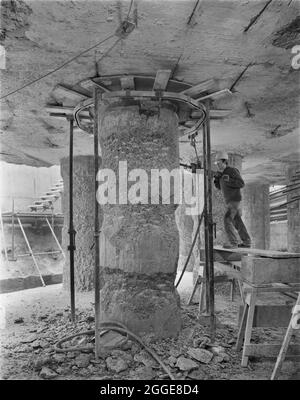 Un ouvrier de Laing utilisant un marteau à inertie pour texturer une grande colonne de soutien en béton, pendant les travaux sur les fondations du développement de Barbican. Cette image a été cataloguée dans le cadre du projet Breaking New Ground en partenariat avec la John Laing Charitable Trust en 2019-20. Banque D'Images