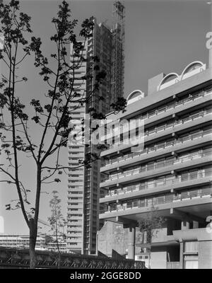 Une vue du nord-ouest vers la construction de la Tour Cromwell sur le site de développement de Barbican, avec le bloc de terrasse Speed House sur la droite. Les travaux de construction du développement Barbican de Londres&#x2019;s ont commencé en 1962. La construction de ce complexe megastructure a été conçue pour être réalisée en six phases, avec différents entrepreneurs travaillant sur le site. En 1964, John Laing et son Ltd ont remporté l'appel d'offres pour la phase III Laing était également responsable de la construction de la phase V, qui comprenait le Barbican Arts Centre, Frobisher Crescent et l'école de musique et de théâtre Guildhall. Banque D'Images