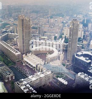 Vue sur le développement Barbican achevé depuis un point de vue élevé vers le sud-est, montrant la Tour Shakespeare (à gauche) et la Tour Cromwell (à droite) de chaque côté du croissant Frobisher. Les travaux de construction du développement Barbican de Londres&#x2019;s ont commencé en 1962. La construction de ce complexe megastructure a été conçue pour être réalisée en six phases, avec différents entrepreneurs travaillant sur le site. En 1964, John Laing et son Ltd ont remporté l'appel d'offres pour la phase III Laing était également responsable de la construction du Barbican Arts Centre, phase V, qui a commencé au début des années 1970 et s'est achevé en 19 Banque D'Images