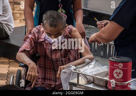 Un agent de santé administre le vaccin Pfizer-BioNTech Covid-19 à un homme âgé de l'école secondaire Raj Pracha à Samut Prakarn.l'hôpital Bang Chak de la province de Samut Prakarn a ouvert une vaccination sans rendez-vous pour les résidents de Samut Prakarn qui recevront leur première dose du vaccin Pfizer à Raj Pracha High, Province de Samut Prakarn à haut risque les résidents qui se sont qualifiés pour le vaccin sont âgés de plus de 60 ans, sont enceintes ou ont des conditions préexistantes ont reçu leur première dose du vaccin Pfizer-BioNTech COVID-19 à partir de 8h00 et se terminant à 14h00, du 30 août au 1er septembre 2021 Banque D'Images