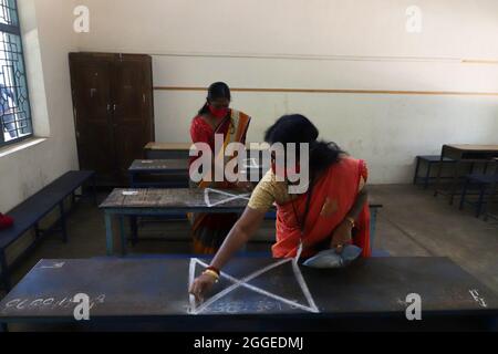 Chennai, Tamil Nadu, Inde. 31 août 2021. Les enseignants tirent des marques de distanciation sociale sur les bancs des salles de classe d'une école gouvernementale pour empêcher la propagation de la maladie du coronavirus COVID-19 avant la réouverture des écoles suite à la facilité des restrictions de confinement de la COVID-19 à Chennai. Les écoles et les collèges de l'État de Tamil Nadu doivent rouvrir à partir du 01 septembre. (Image de crédit : © Sri Loganathan/ZUMA Press Wire) Banque D'Images