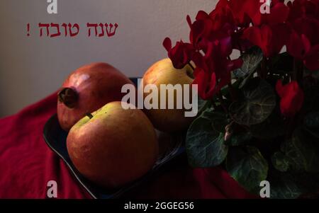 Rosh Hashanah les fêtes du nouvel an juif encore la vie avec des pommes et un fond grenade. Message de bonne année en texte hébreu. Banque D'Images