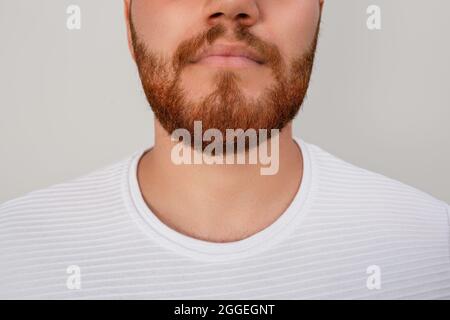 Gros plan du visage de jeune barbu rouge isolé sur fond blanc. Photo de haute qualité Banque D'Images