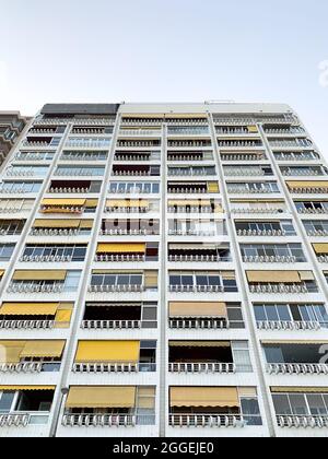 Angle bas d'un immeuble résidentiel aux parois de verre sous un ciel lumineux et ensoleillé Banque D'Images