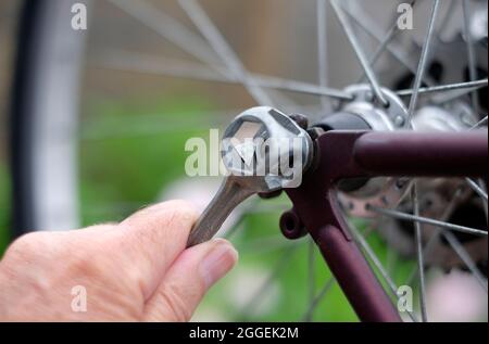 homme serrage de l'écrou de roue sur vtt avec une clé, norfolk, angleterre Banque D'Images