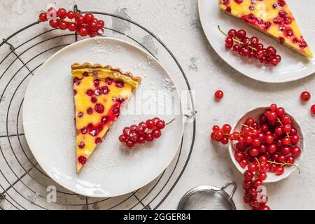 Morceaux de tarte au cassis maison sur fond blanc, décorés de raisins de Corinthe rouges frais, vue du dessus Banque D'Images