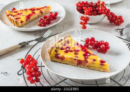 Morceau de tarte au cassis maison sur fond blanc, décoré de groseilles rouges fraîches Banque D'Images