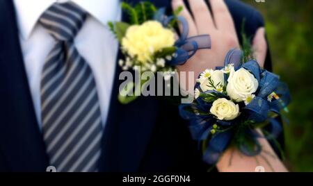 Mains de date Prom nuit fleurs fleur en relief habillé porter main sur l'épaule mise au point sélective flou Banque D'Images
