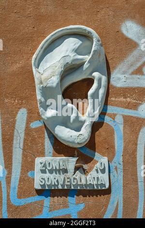 Une sculpture en plâtre représentant une grande oreille, art de rue par Urbansolid, apposée sur un mur de graffiti dans le quartier de la Nouvelle Venise, Livourne, Toscane, Italie Banque D'Images