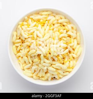 Gros plan de Crunchy Lemon Bhel dans un bol en céramique blanc fait avec du riz soufflé petit besan sev. En-cas indiens épicés (Namkeen), vue de dessus Banque D'Images