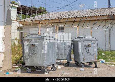 Trois poubelles à roues métalliques sur le site industriel Banque D'Images