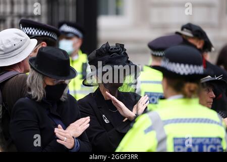 Londres, Angleterre, Royaume-Uni. 31 août 2021. Groupe de campagne sur le changement climatique extinction les militants de la rébellion portant des robes funéraires se collent eux-mêmes aux landaus devant l'entrée principale de Downing Street lors d'une manifestation à Westminster. (Image de crédit : © Tayfun Salci/ZUMA Press Wire) Banque D'Images
