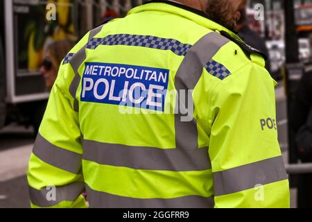 Londres, Angleterre - août 2021 : vue arrière d'un officier de police métropolitain portant une veste réfléchissante. Banque D'Images