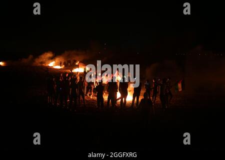 Territoires palestiniens, bande de Gaza. 31 août 2021. Les manifestants palestiniens brûlent des pneus en caoutchouc lors d'affrontements avec l'armée israélienne surnommée « confusion nocturne » le long de la bande de Gaza séparant la bande de Gaza et Israël à l'est de Khan Yunis, dans le sud de la bande de Gaza, pour protester contre le blocus en cours sur la bande de Gaza. Gaza. Banque D'Images