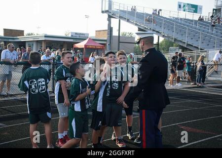 Brian Hubert, commandant de Recruiting Station Cleveland, Marine des États-Unis, discute avec des joueurs de football junior lors d'un match de football à l'école secondaire à Westlake, Ohio, le 27 août 2021. Hubert et une autre Marine ont levé les couleurs pendant l'hymne national pour honorer les 13 membres du service américain tués à Kaboul, en Afghanistan, en août 2021. (É.-U. Photo du corps marin par Cpl. Mello Miele) Banque D'Images
