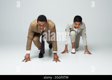 les hommes d'affaires afro-américains commencent à poser avant de courir sur le gris Banque D'Images