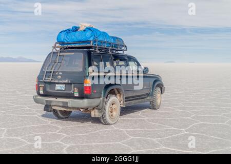 SALAR DE UYUNI, BOLIVIE - 17 AVRIL 2015 : 4X4 avec des touristes au plat salin de Salar de Uyuni, Bolivie Banque D'Images