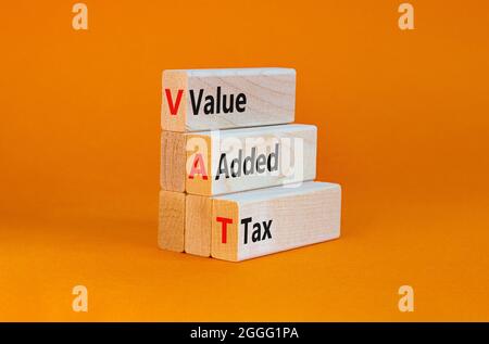 Symbole TVA, taxe sur la valeur ajoutée. Blocs en bois avec des mots de concept "TVA, taxe sur la valeur ajoutée". Magnifique arrière-plan orange, espace de copie. Affaires et TVA, valeur Banque D'Images