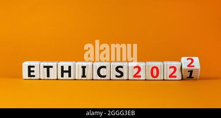 2022 éthique et symbole de la nouvelle année. A transformé un cube en bois et a changé les mots 'Ethics 2021' en 'Ethics 2022'. Magnifique arrière-plan orange, espace de copie. Bus Banque D'Images