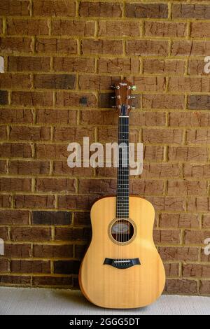 Taylor Guitar sur Brick Wall Banque D'Images